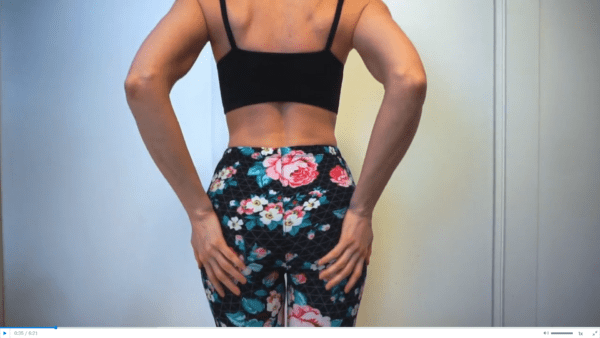 woman wearing a black bra and black flowered leggings doing a panty try on