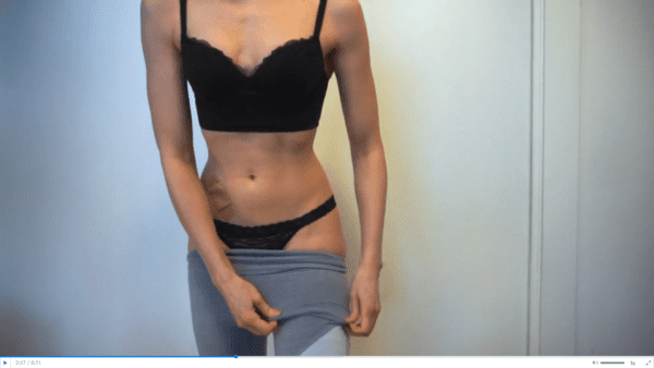 woman wearing black bra and black panties pulling up grey yoga pants in panty try on