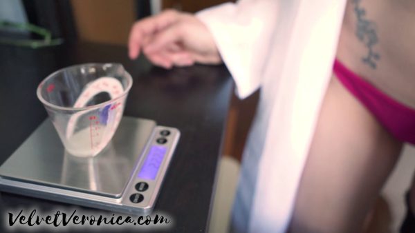 woman wearing white lab coat measuring cum ejaculate on weigh scale