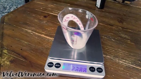 measuring cup with cum ejaculate being weighed on a scale